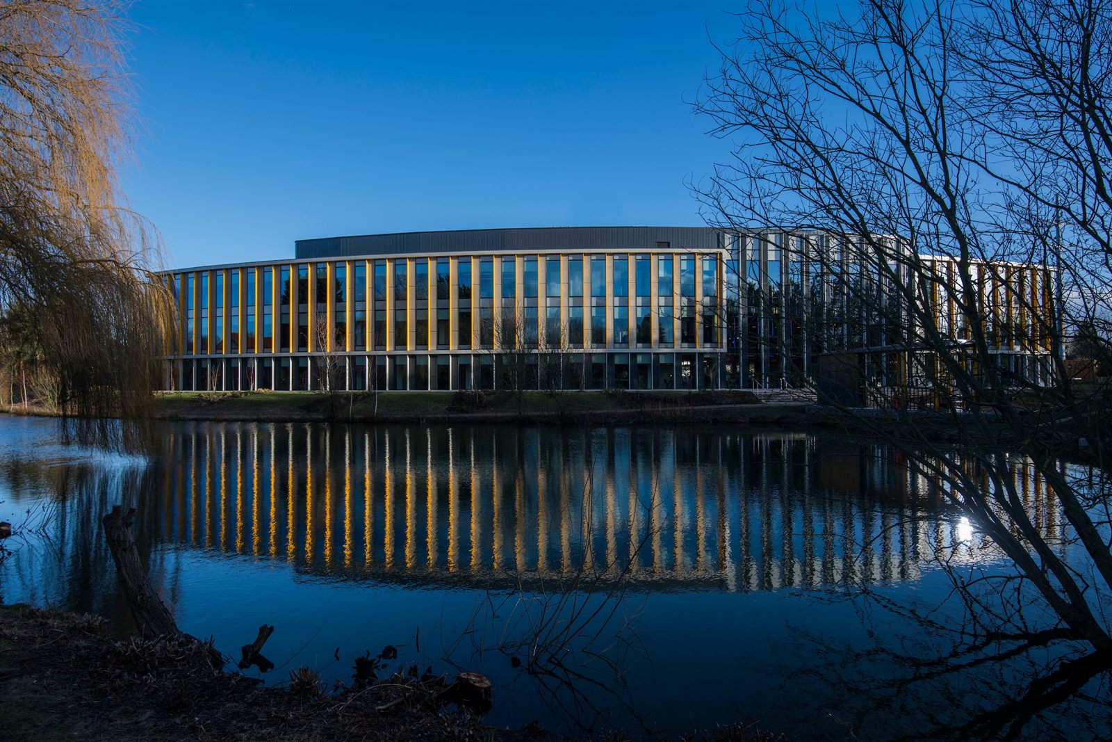 Exterior lakeside view of The Bradfield Centre at Cambridge Science Park